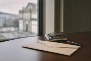 Citación judicial doblada con sello difuso sobre mesa de despacho oscura junto a una pluma y libreta, evocando un juicio rápido por delitos.