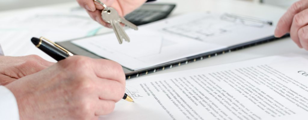 Client signing a real estate contract in real estate agency
