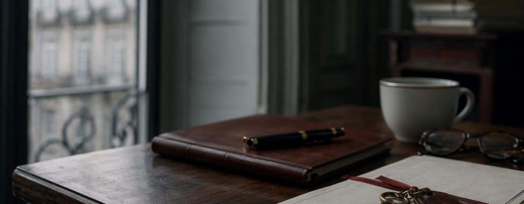 Llave antigua sobre un documento notarial doblado en una mesa de despacho, evocando el desahucio por precario entre coherederos sobre un inmueble heredado.